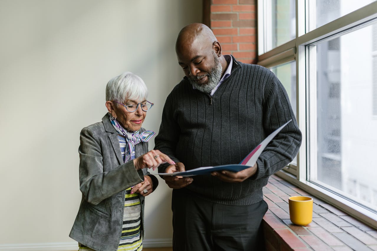 An elderly man and woman having conversation while looking at the folder