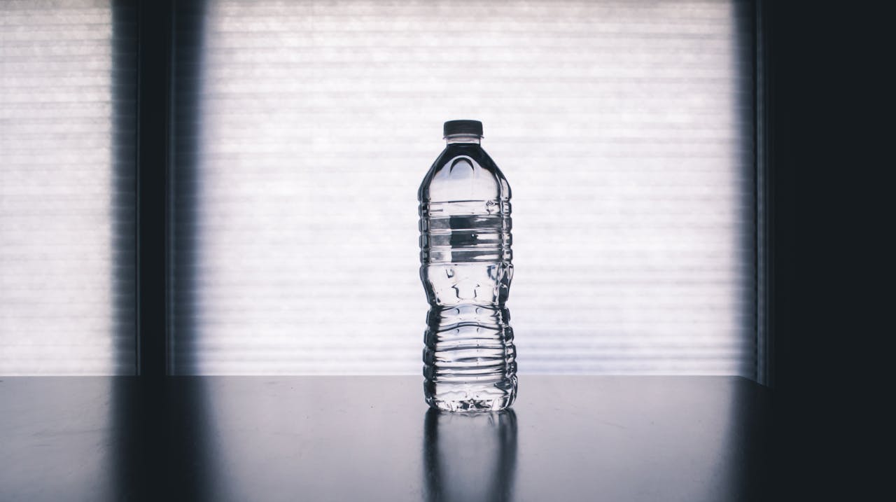Close-up photo of clear disposable bottle on black surface.