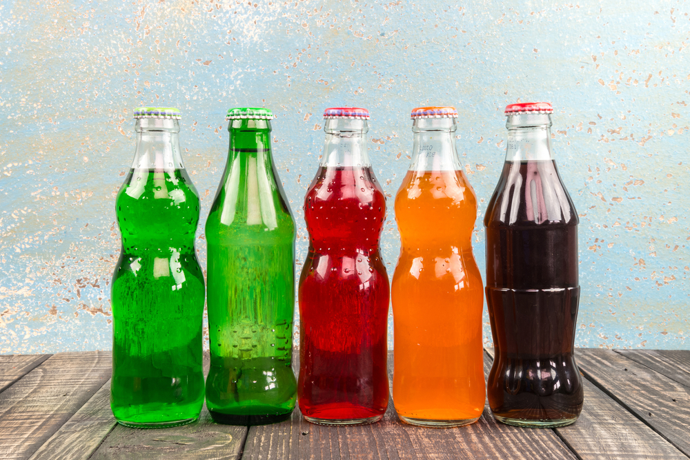 Close-up Photo of Variety of soda bottles on the wooden table