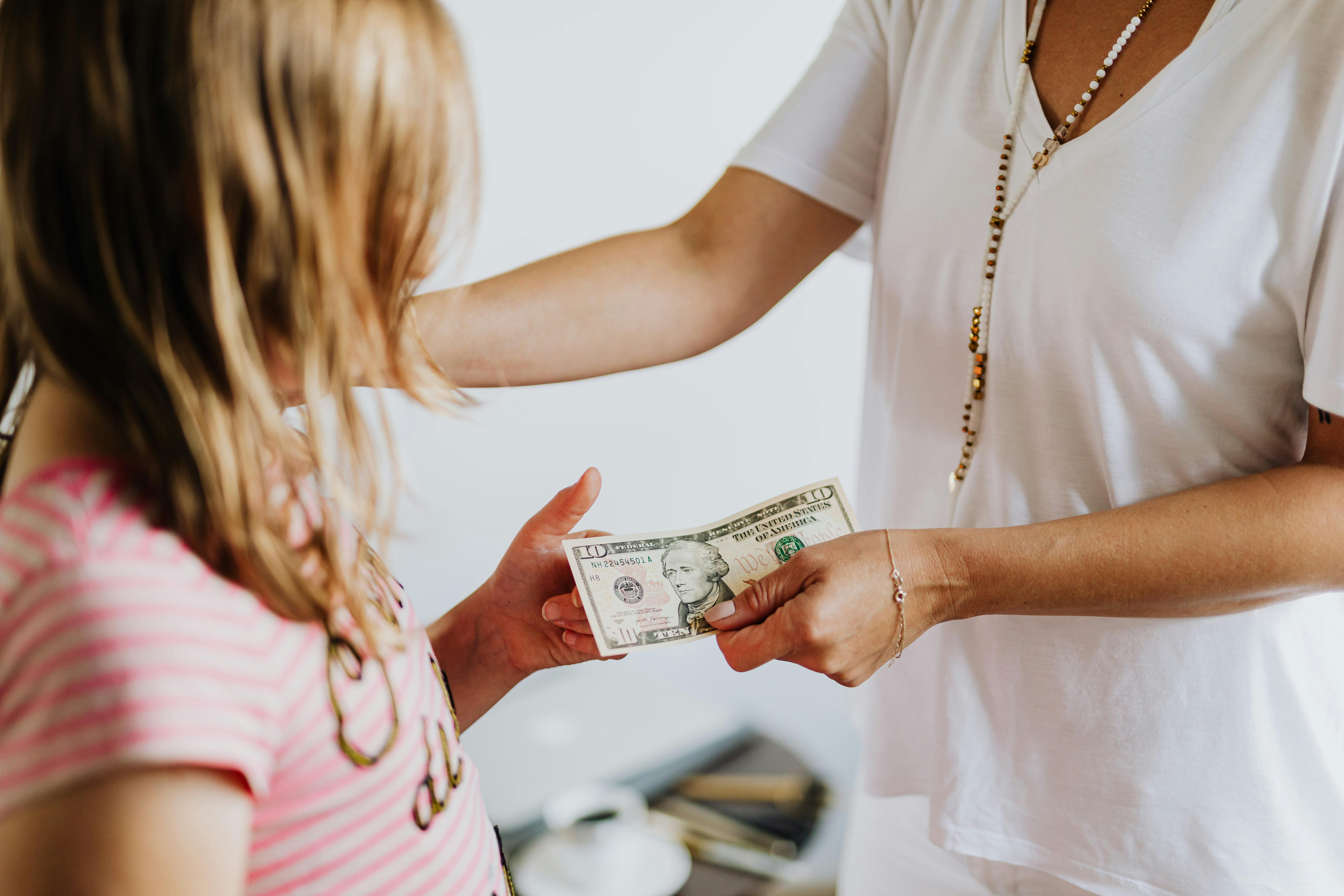Adult person giving money to a child