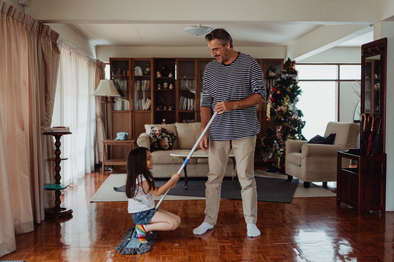 Man and his daughter cleaning their house