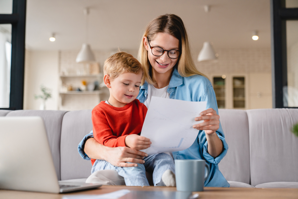 Woman holding her child and reading invoice