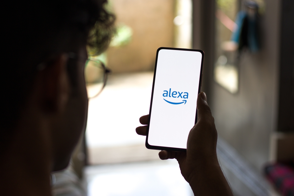 boy holding a phone with amazon alexa open