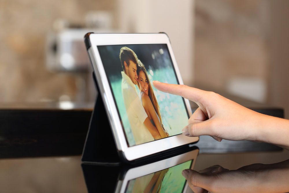 Woman hand using a tablet and watching photos