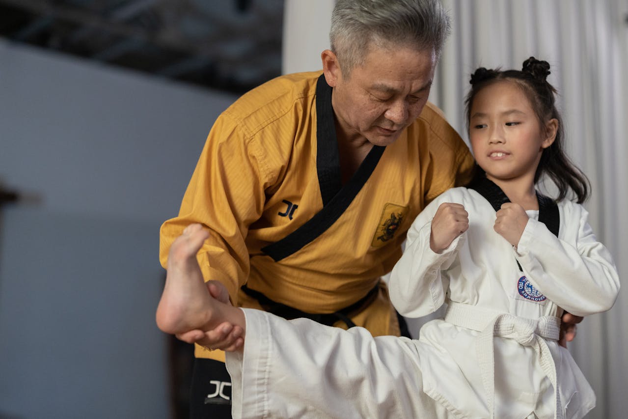 Man Holding a Girls Foot Wearing a Karate Uniform