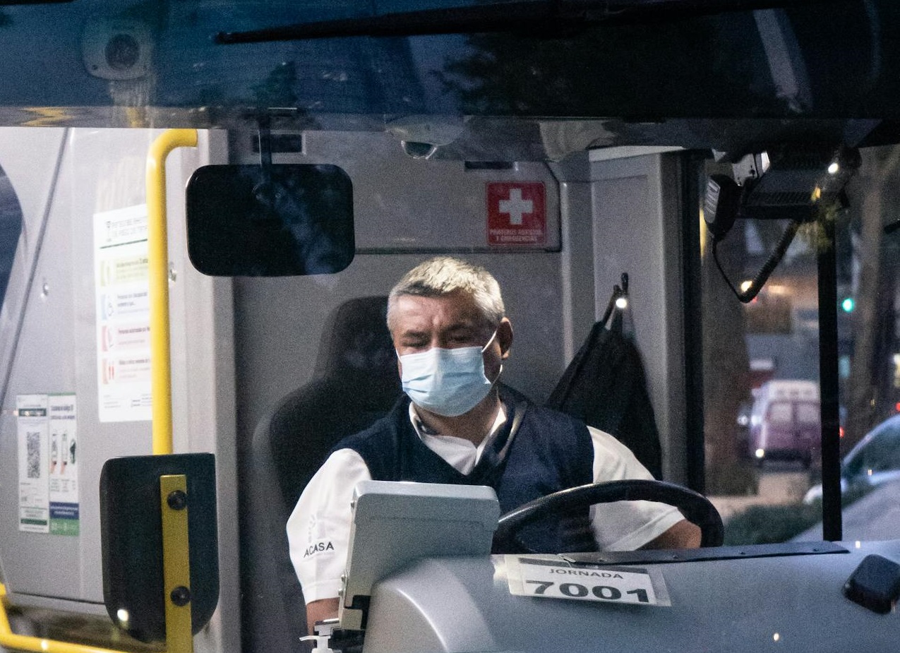 Man Wearing a Face Mask Driving a Bus