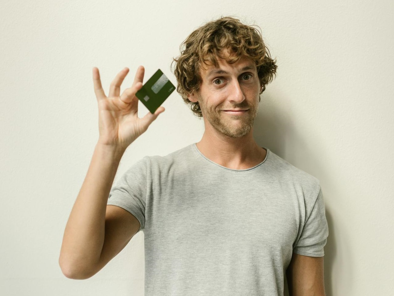 Man in Gray Crew Neck T-shirt Holding a Credit Card