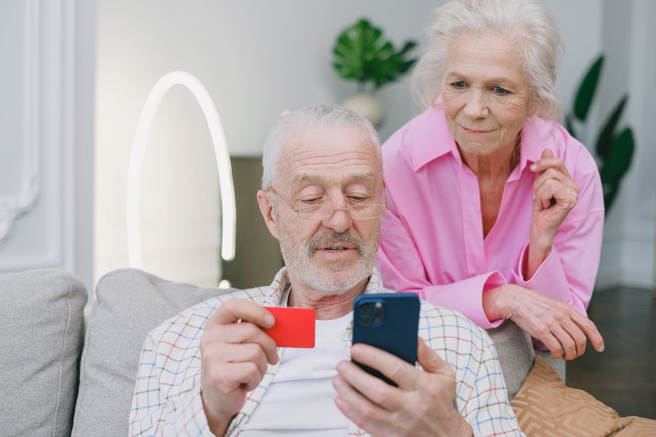 An Elderly Couple Making an Online Transaction over phone.