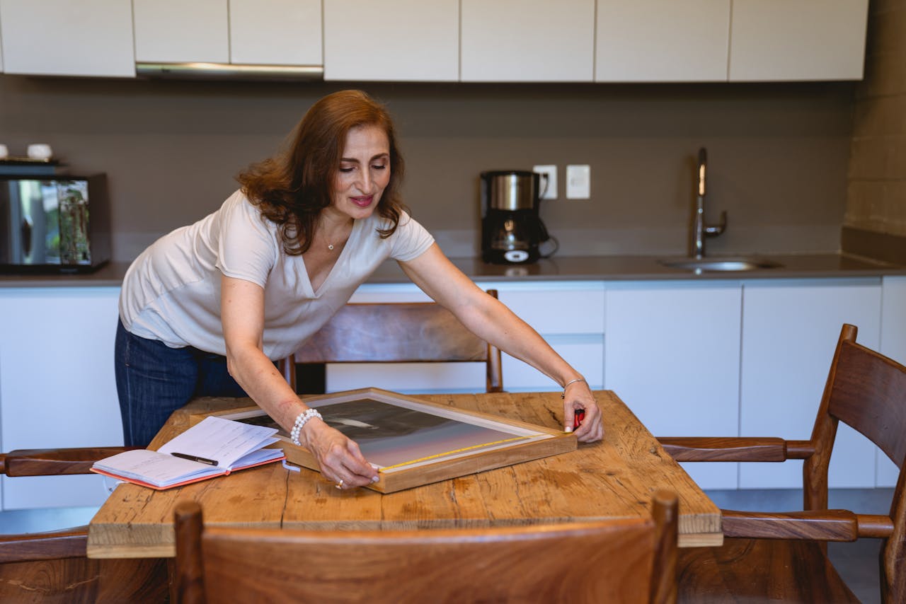 Woman in White Shirt Measuring the Picture Frame