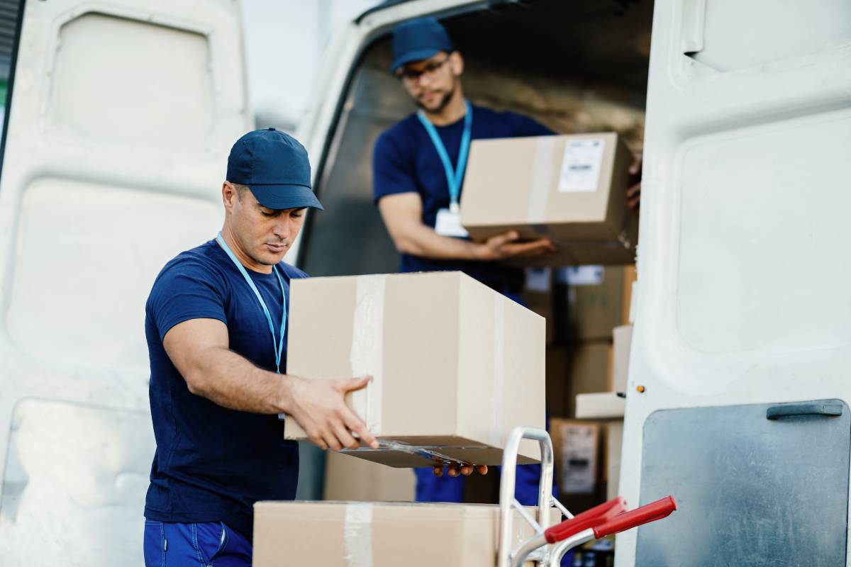 worker loading cardboard boxes in a delivery van