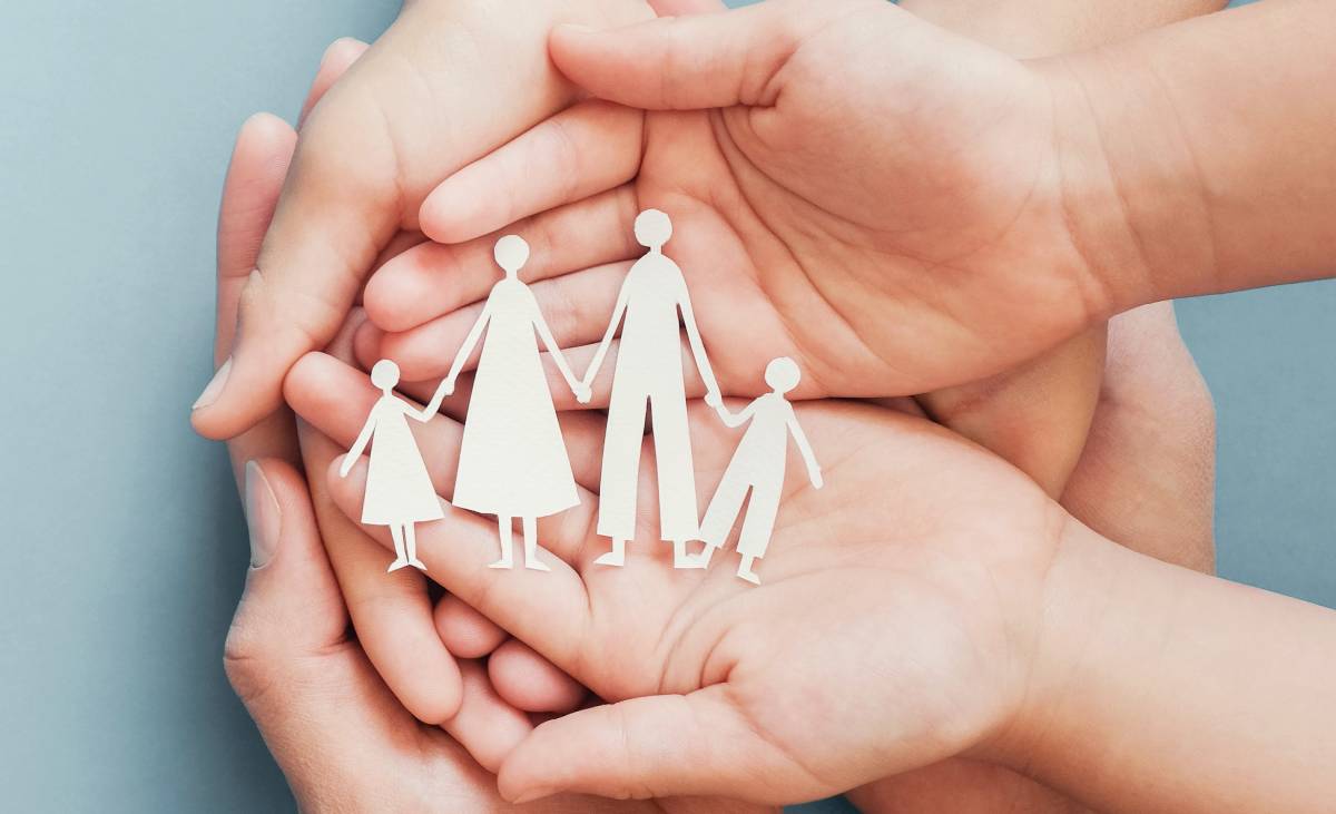 hands holding paper family cutout