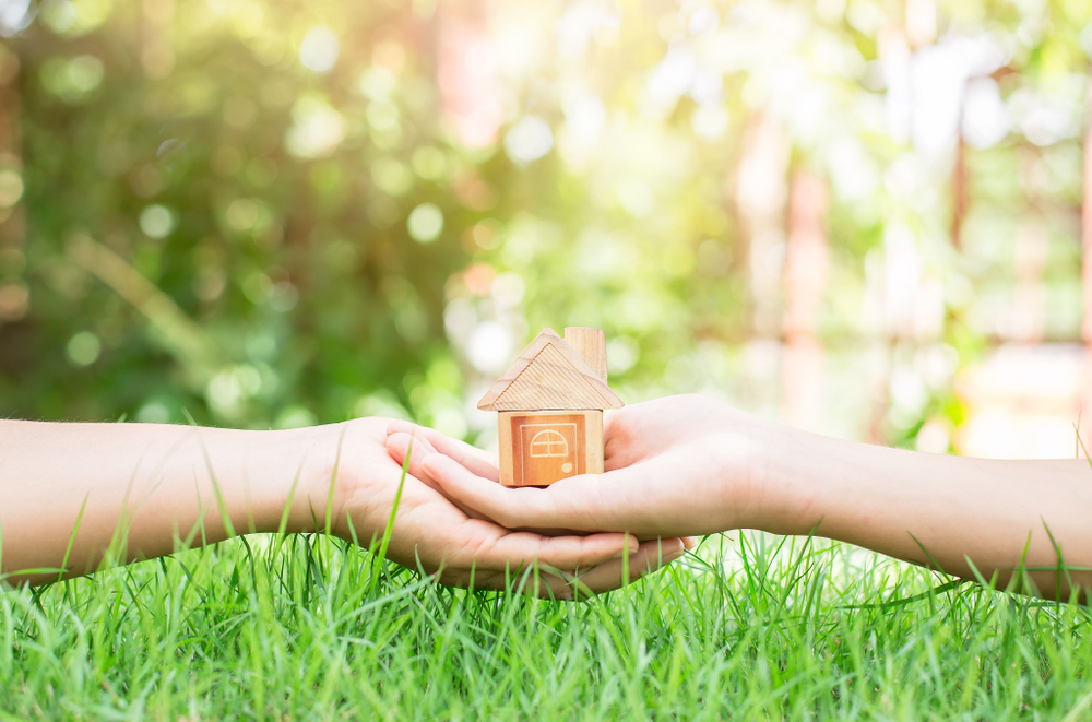 image of a two hand holding wooden house