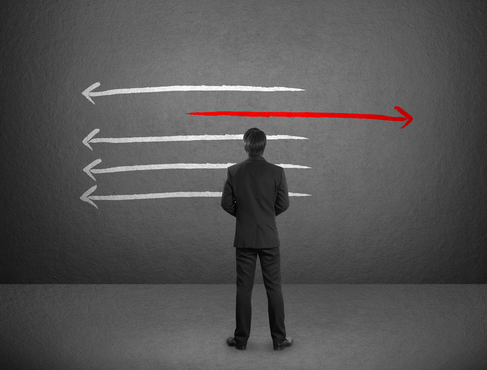 Businessman drawing arrows in different directions