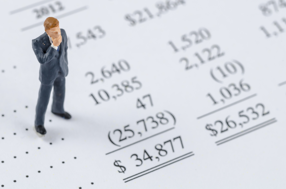 miniature businessman standing on the bottom line