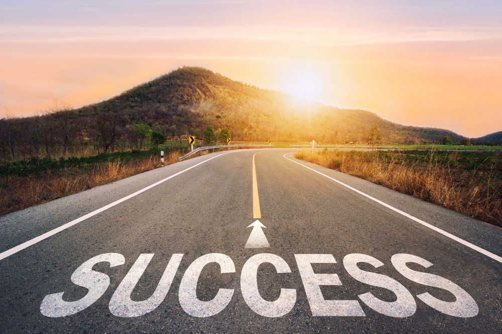 Success written on asphalt road