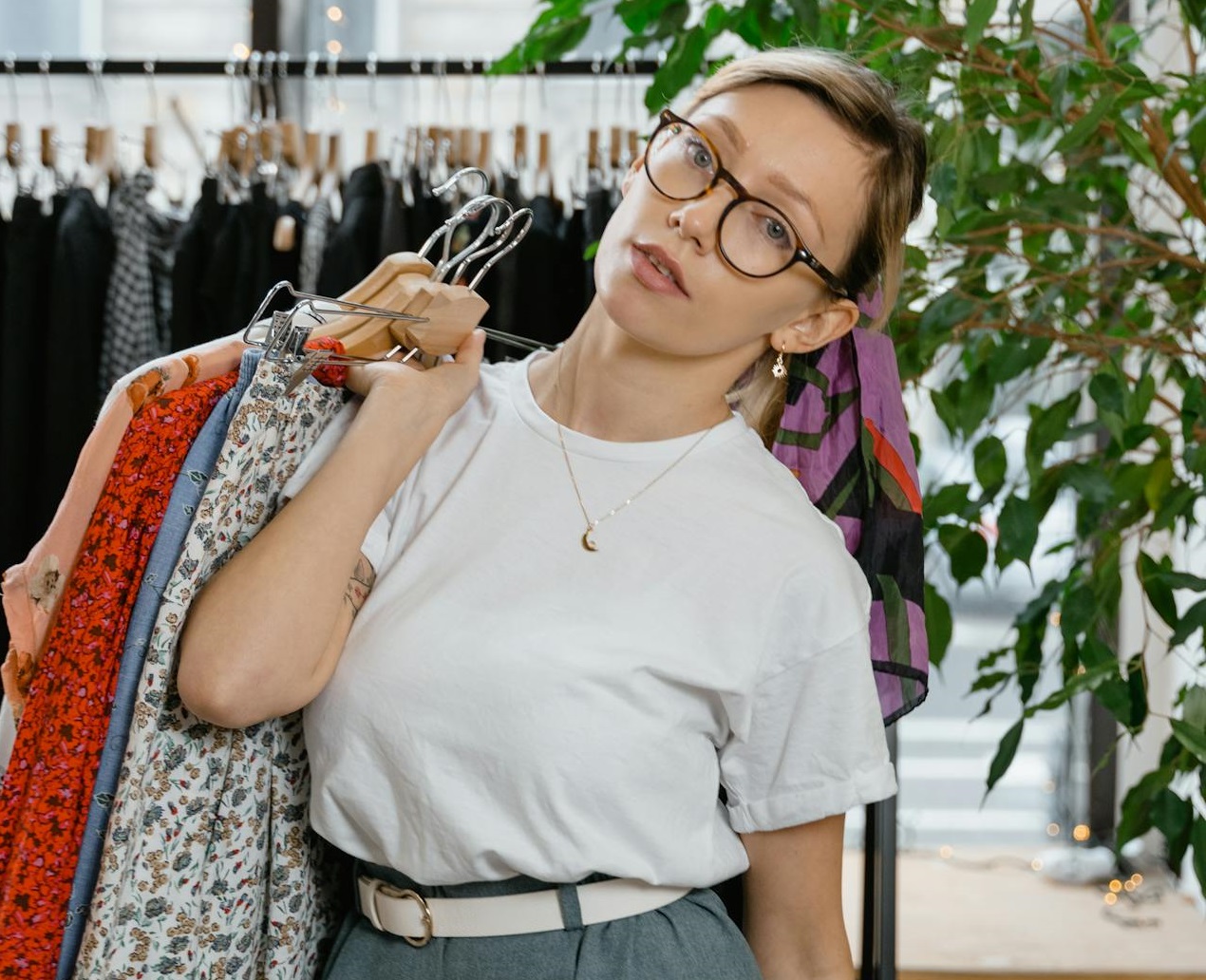 Woman Posing while Carrying Wooden Hangers with Clothes