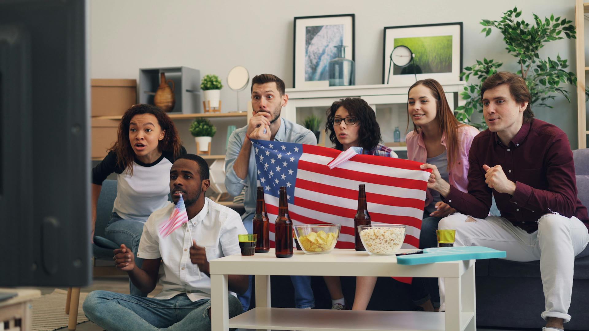 A group of people watching a soccer game with an american flag.