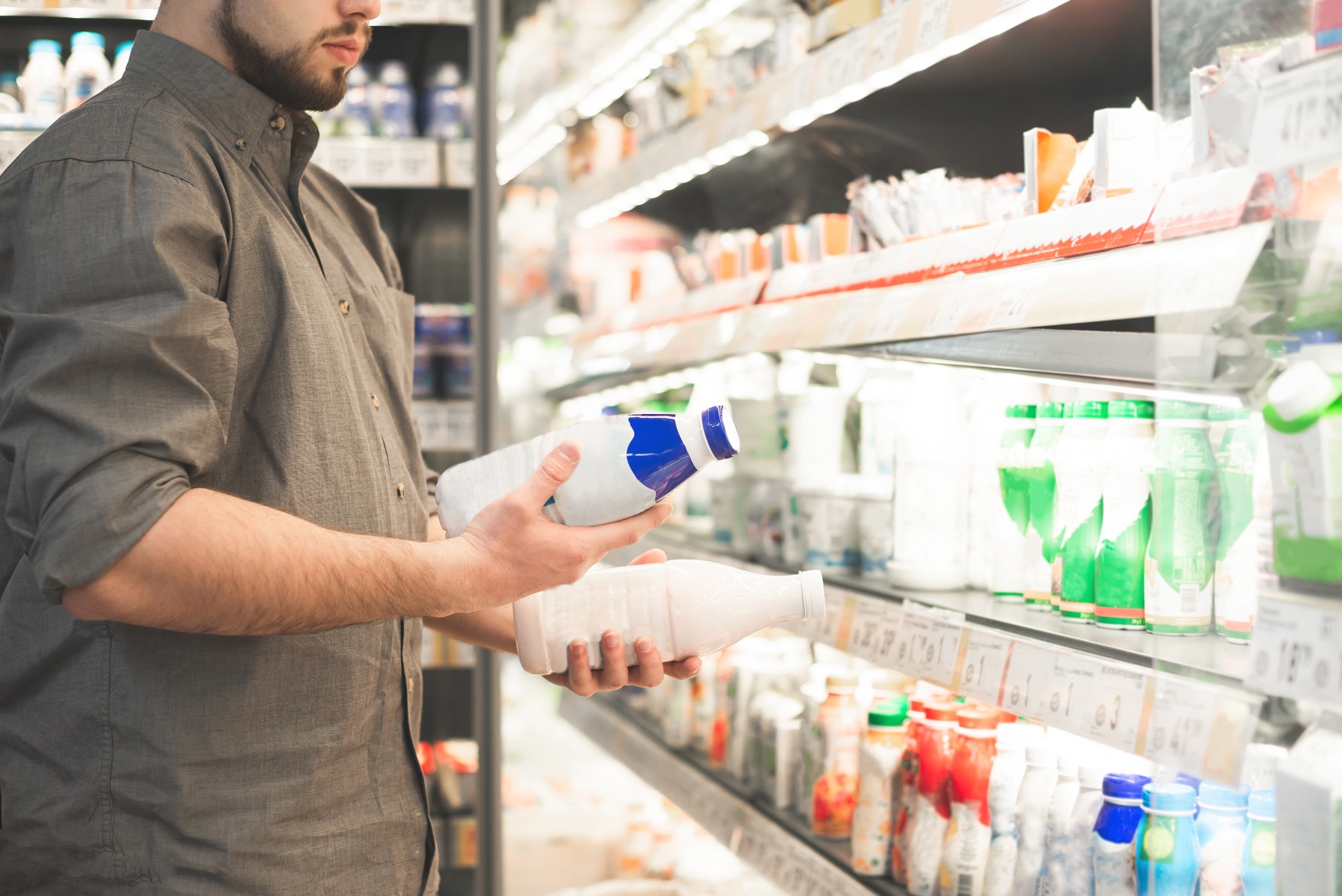 Man in a shirt with two bottles of yogurt in his hands
