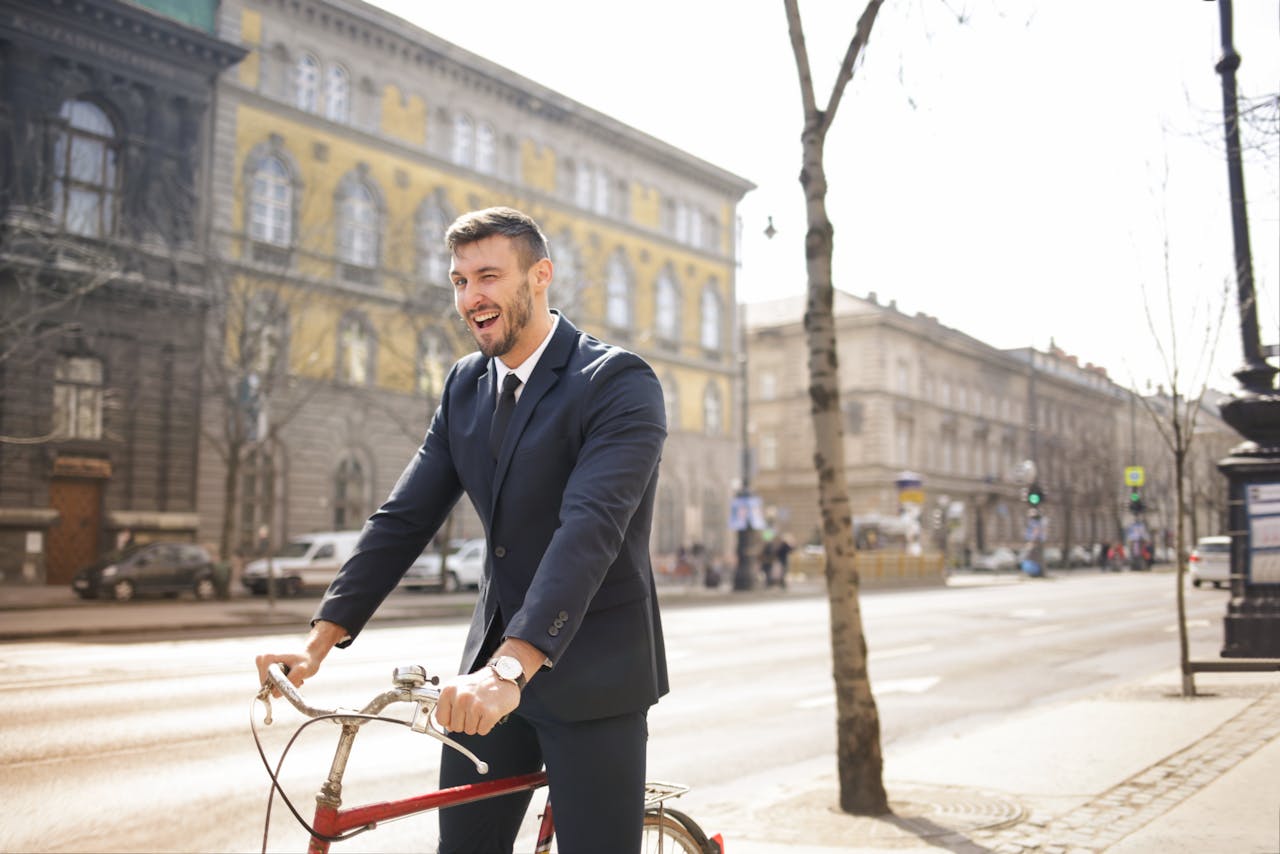 Man in Black Suit Riding a Red Bicycle