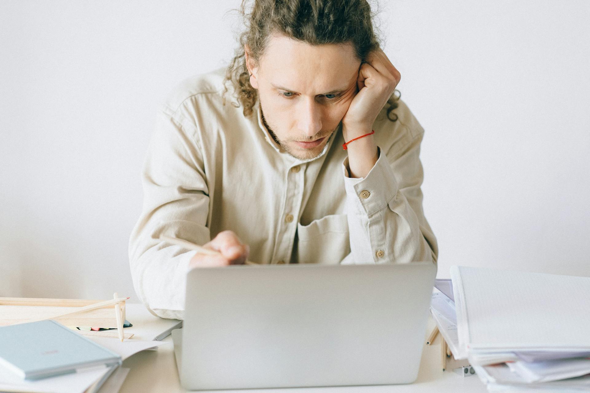 Man in Beige Coat Using Silver Macbook
