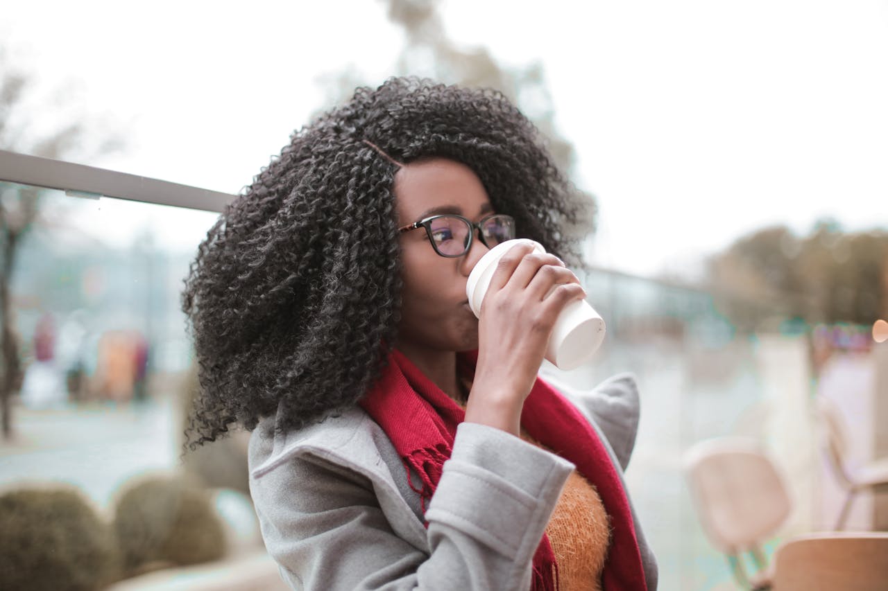 Woman in Gray Coat Drinking Coffee