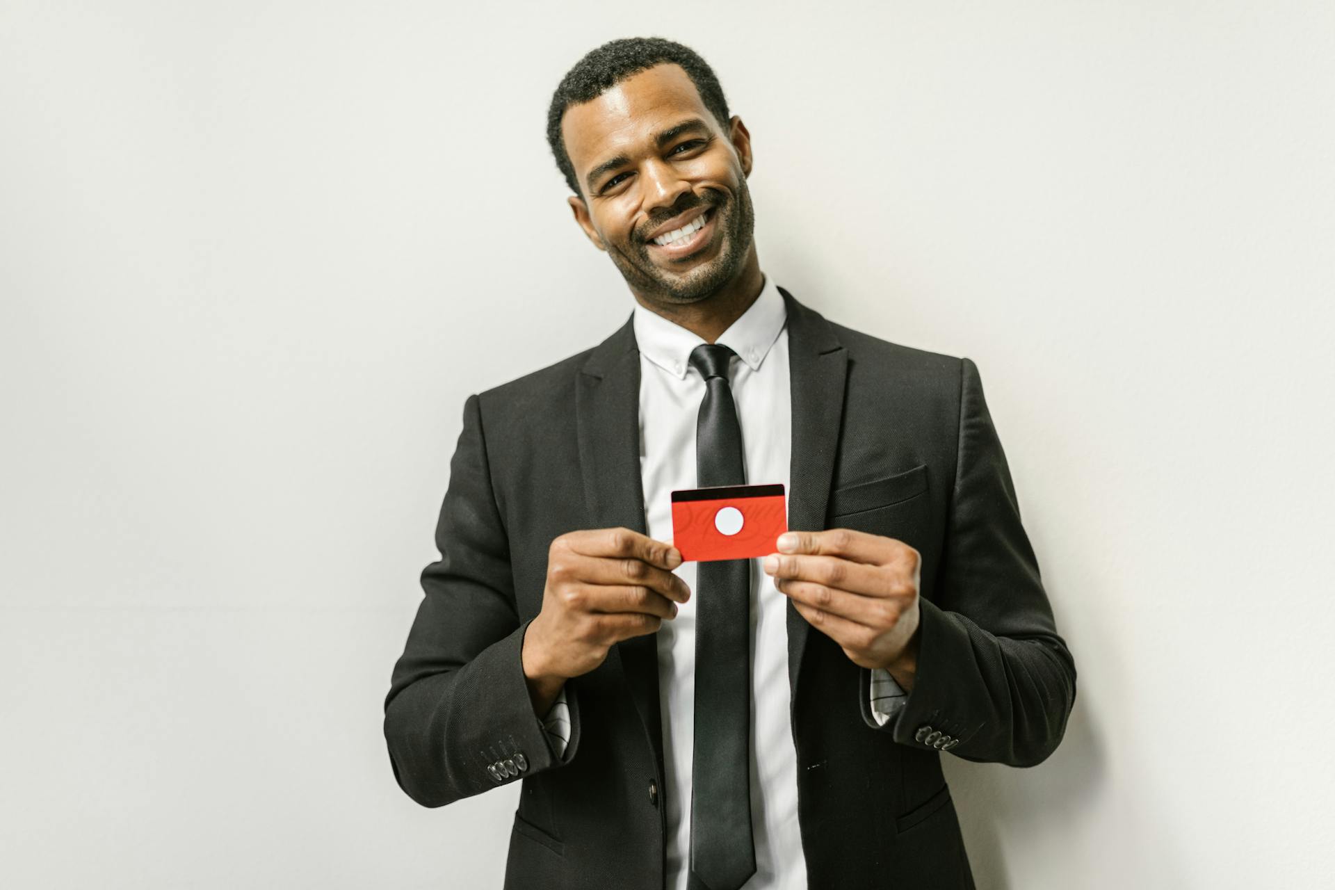 Man in a suit holding a card