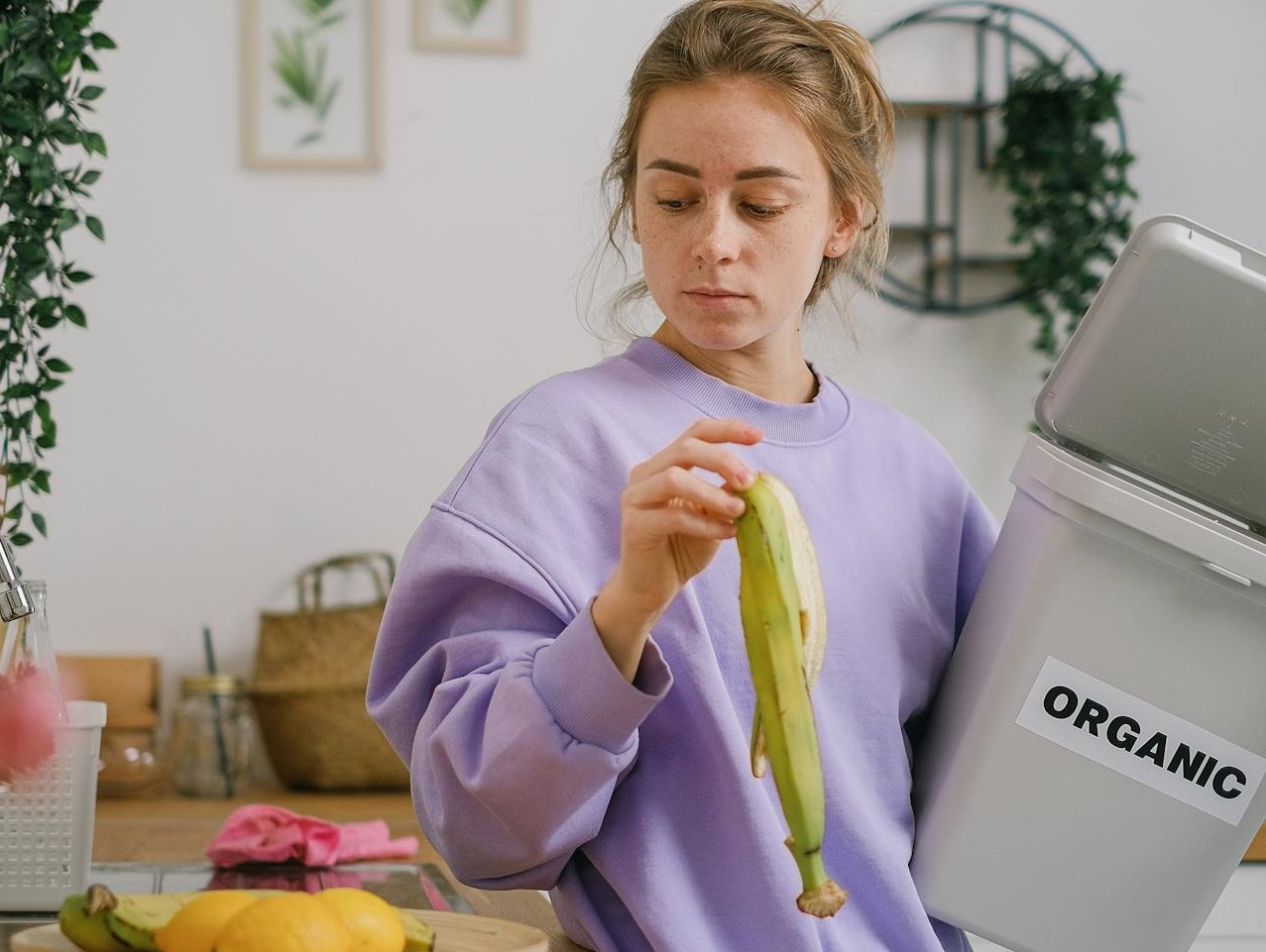 Woman Standing on a Counter Holding a Banana Peel