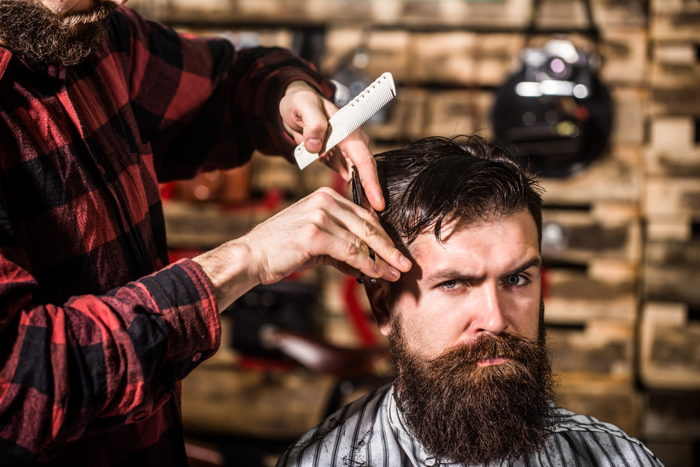 Hairstylist serving client at barber shop