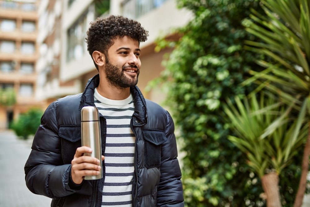Man holding coffee thermos outdoor