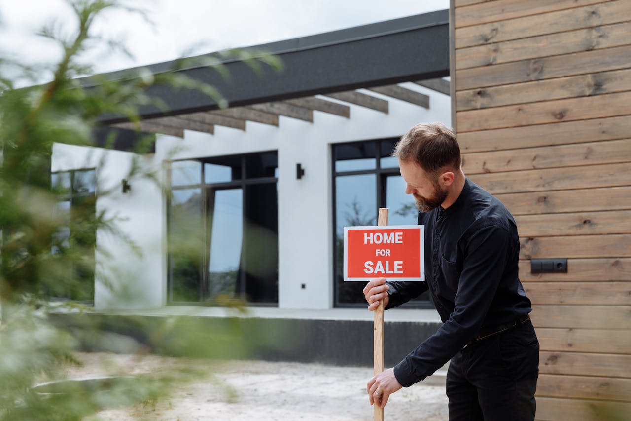 A Man in Black Long Sleeves Putting the Sign