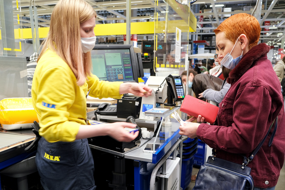 Woman pays for purchases at the checkout of an IKEA hypermarket.