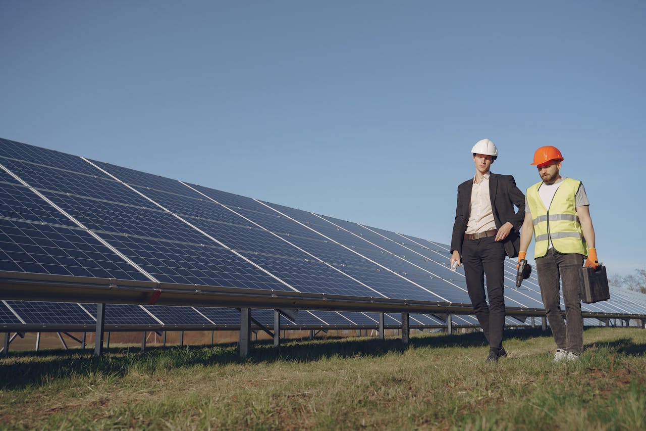 Two Electricians Walking near the Solar Panels