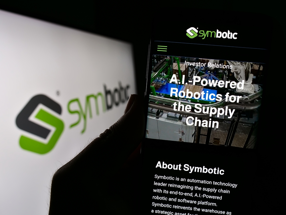 Person holding smartphone with website of US robotics warehouse company Symbotic Inc. on screen with logo.