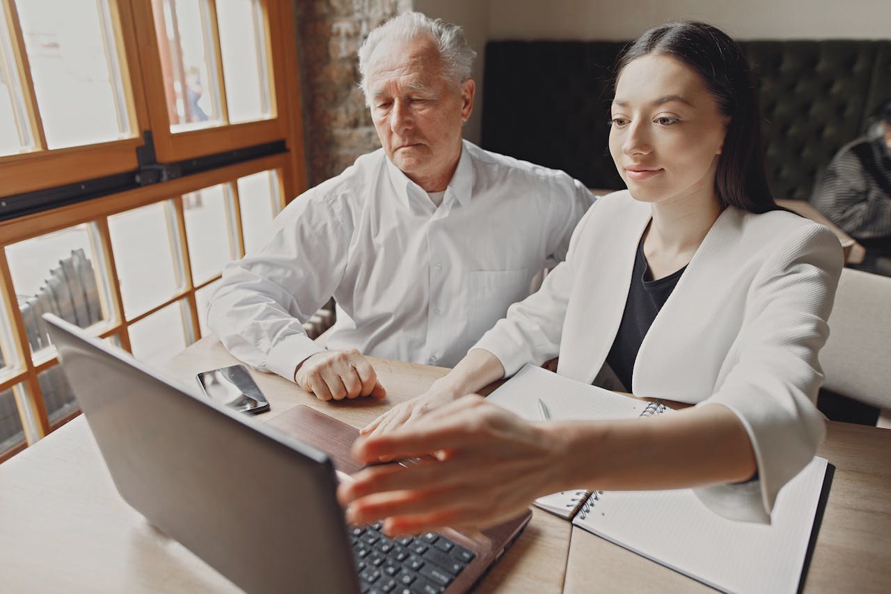 Positive coworkers wearing white outfits browsing laptop