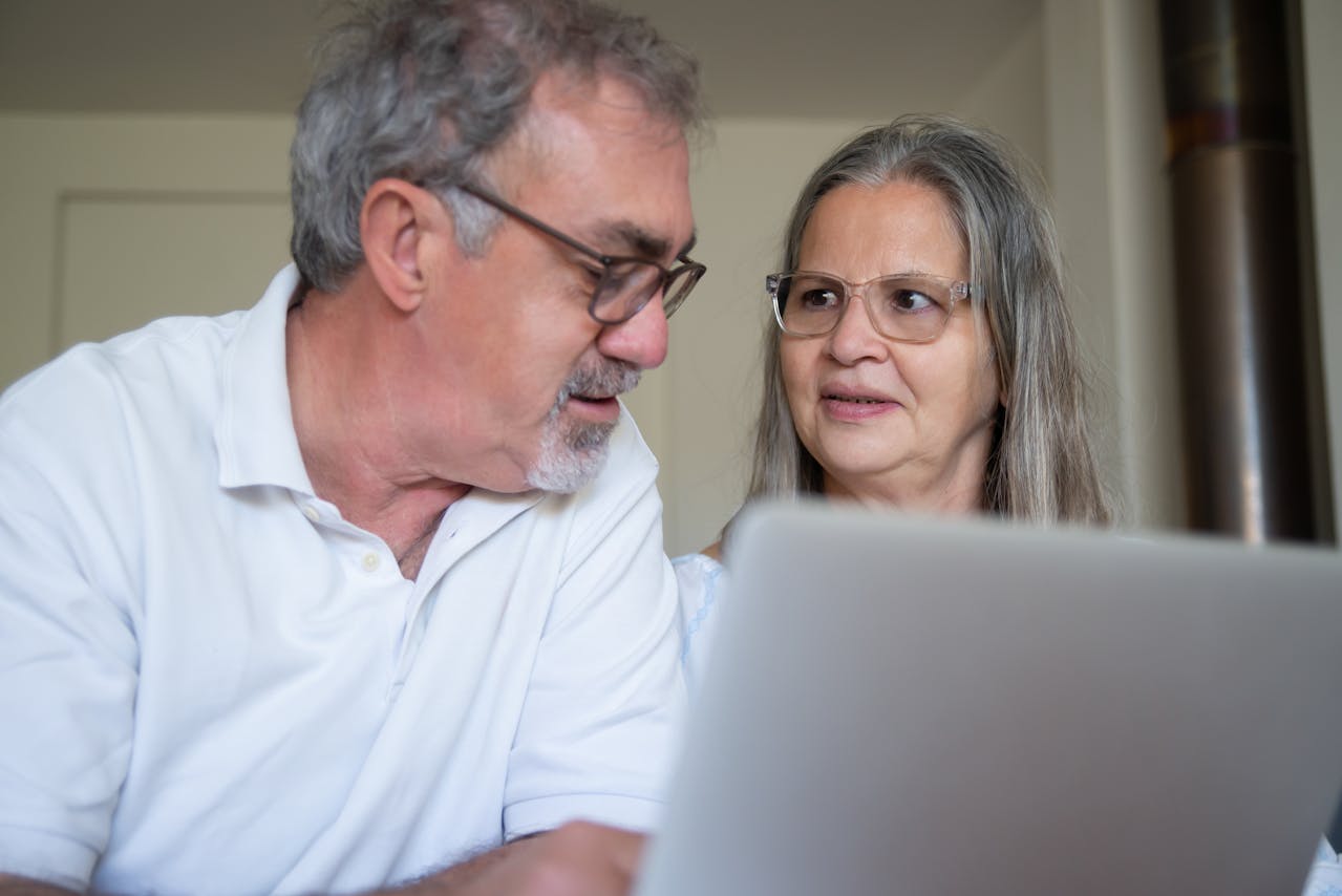 Elderly Couple Sitting in front of a Laptop