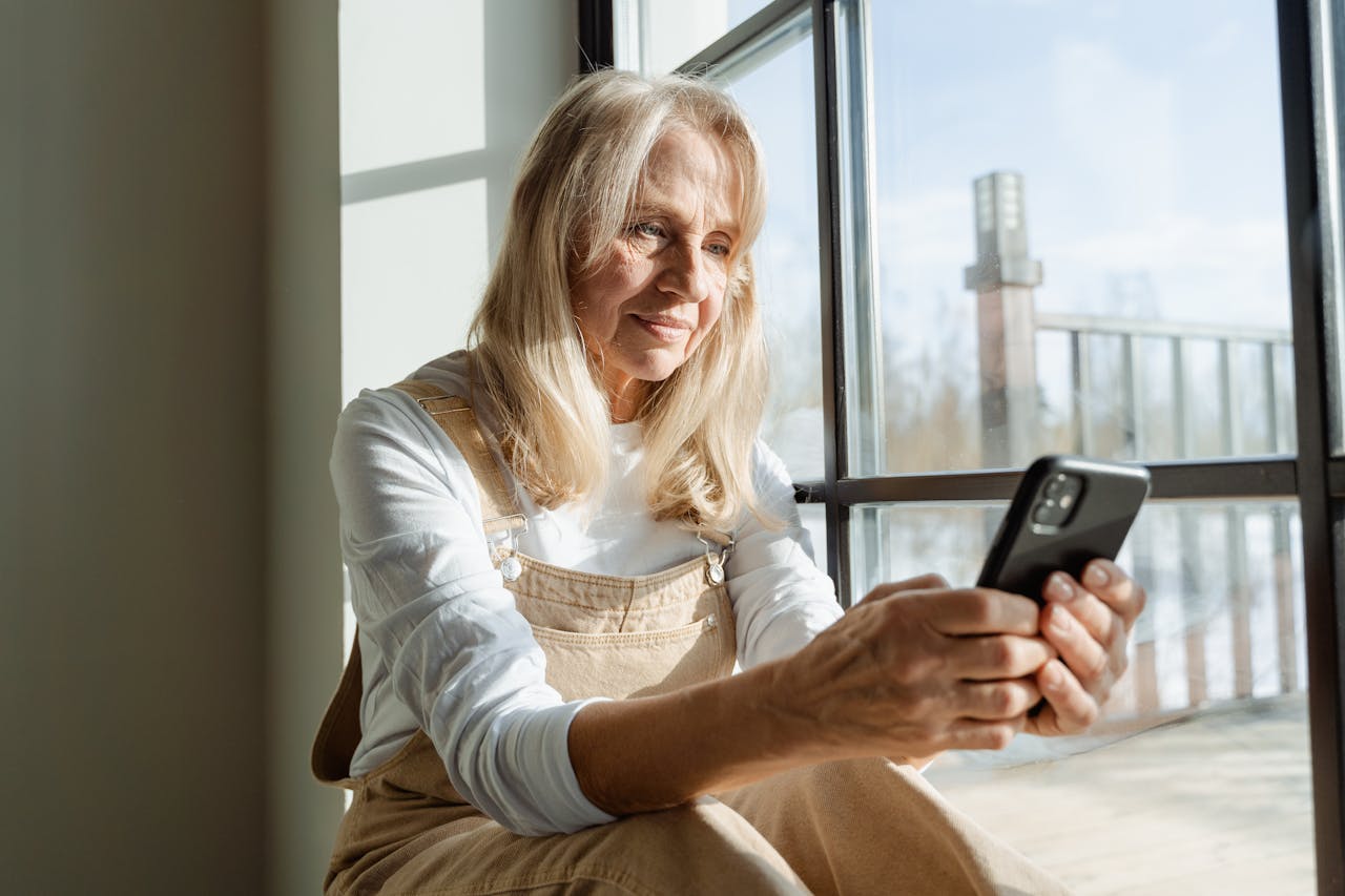 Woman in White Long Sleeve Shirt Using a Mobile Phone