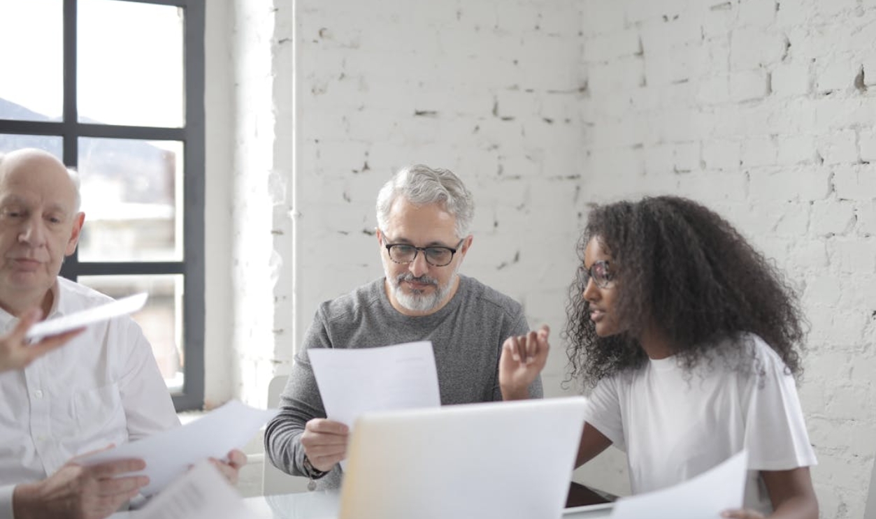 young-african-american-woman-discussing-new-project-with-senior-male-colleague-at-meeting-in-boardroom