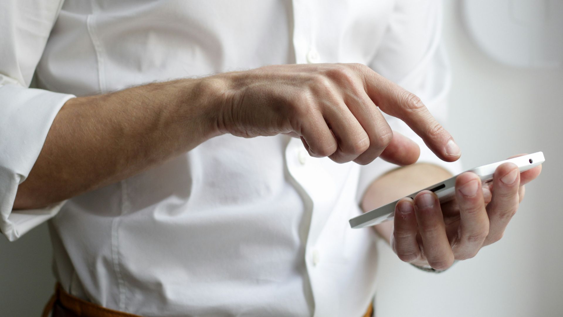 person holding white Android smartphone in white shirt
