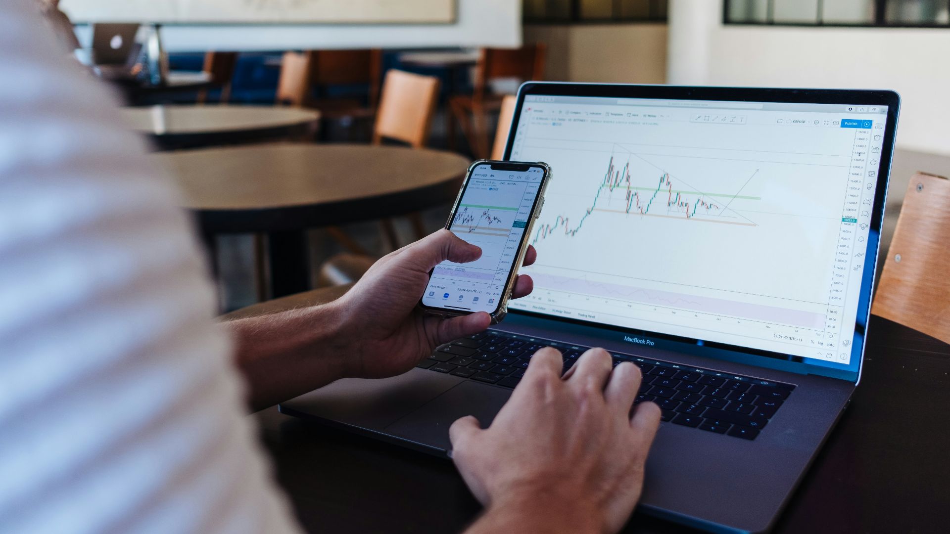 person using smartphone and MacBook Pro