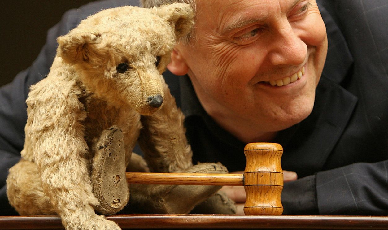Author and former British Member of Parliament Gyles Brandreth poses with 'Growler,' a Steiff rod-bear circa 1904 at Christies auction house in central London, 30 August 2006. Brandreth is the founder and owner of the world's oldest Teddy Bear Museum, based in Stratford-upon-Avon, in England, and is selling the collection of over 1,000 bears and the museum as a going concern. The collection also includes 'Paddington Bear' from the original series and the original 'Fozzie Bear' from The Muppet Show.