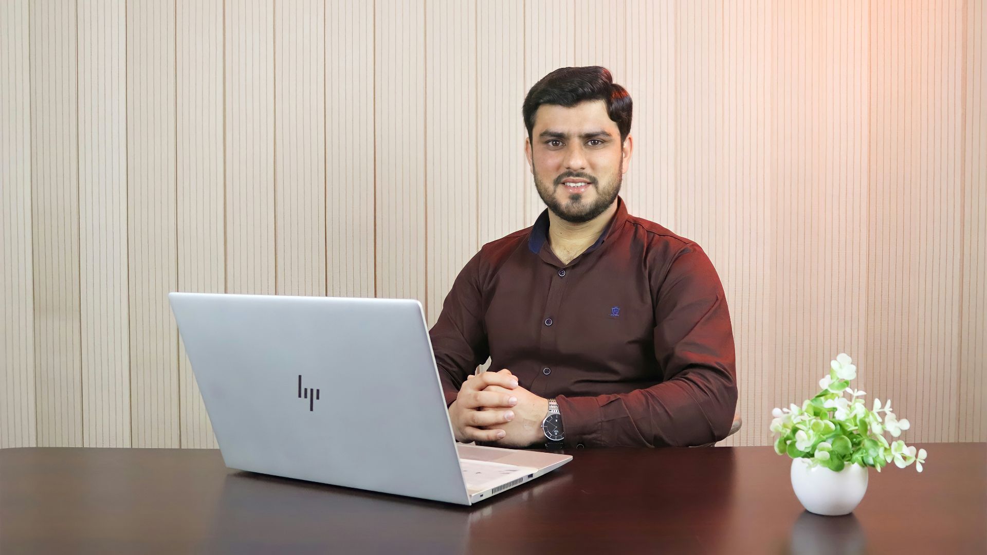 man in red sweater using macbook