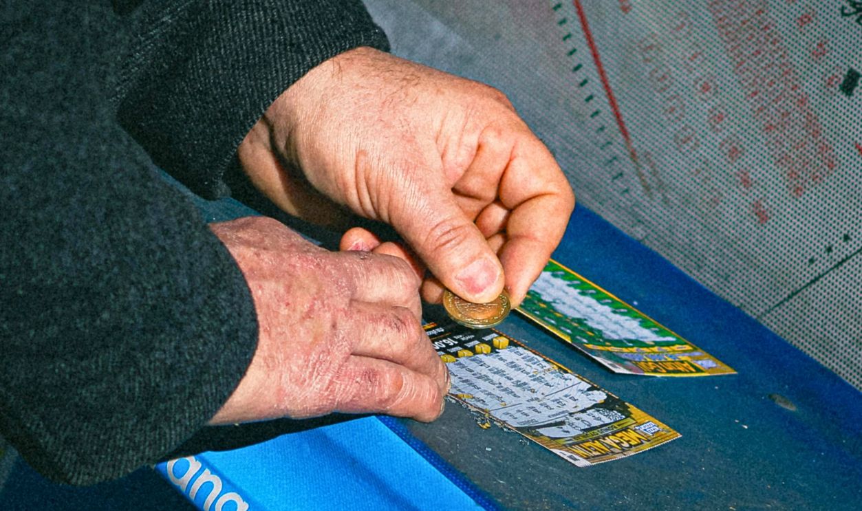 Close-up of hands scratching lottery tickets