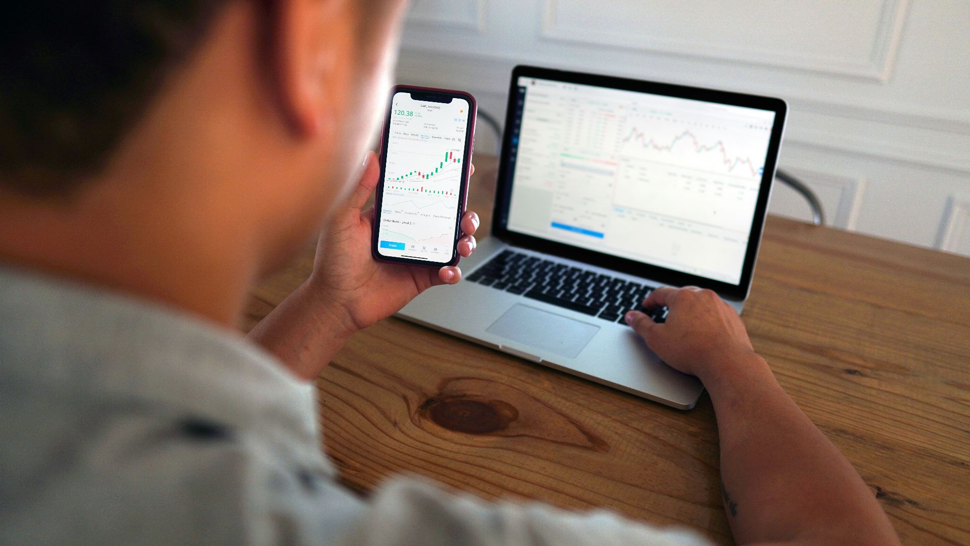 man in gray hoodie holding black smartphone