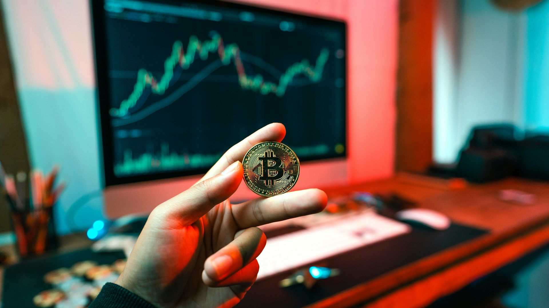 a person holding a coin in front of a computer