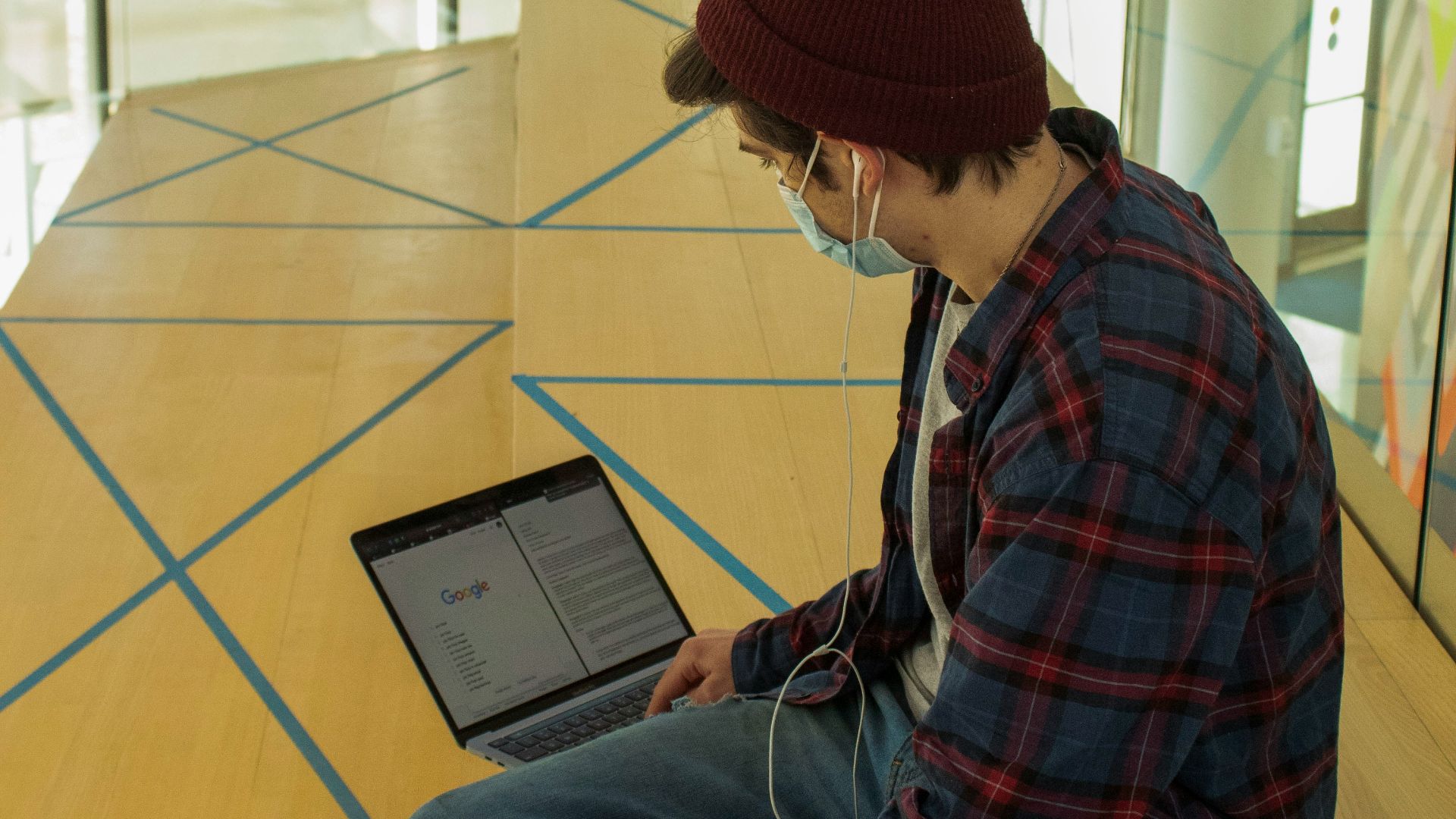 man in red and blue plaid dress shirt using black tablet computer