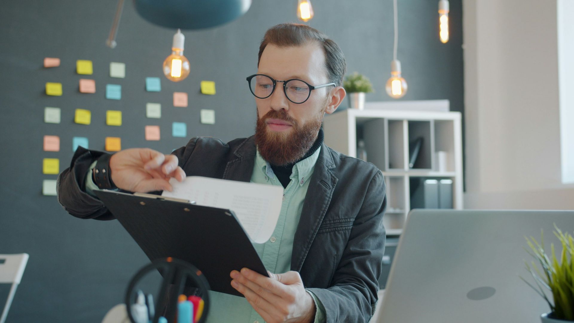 Man in glasses reviewing documents at desk