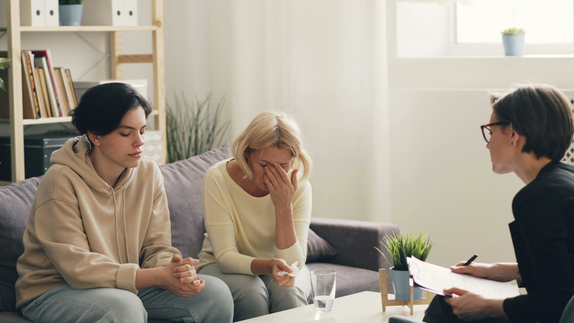 two women sitting on a couch talking to each other