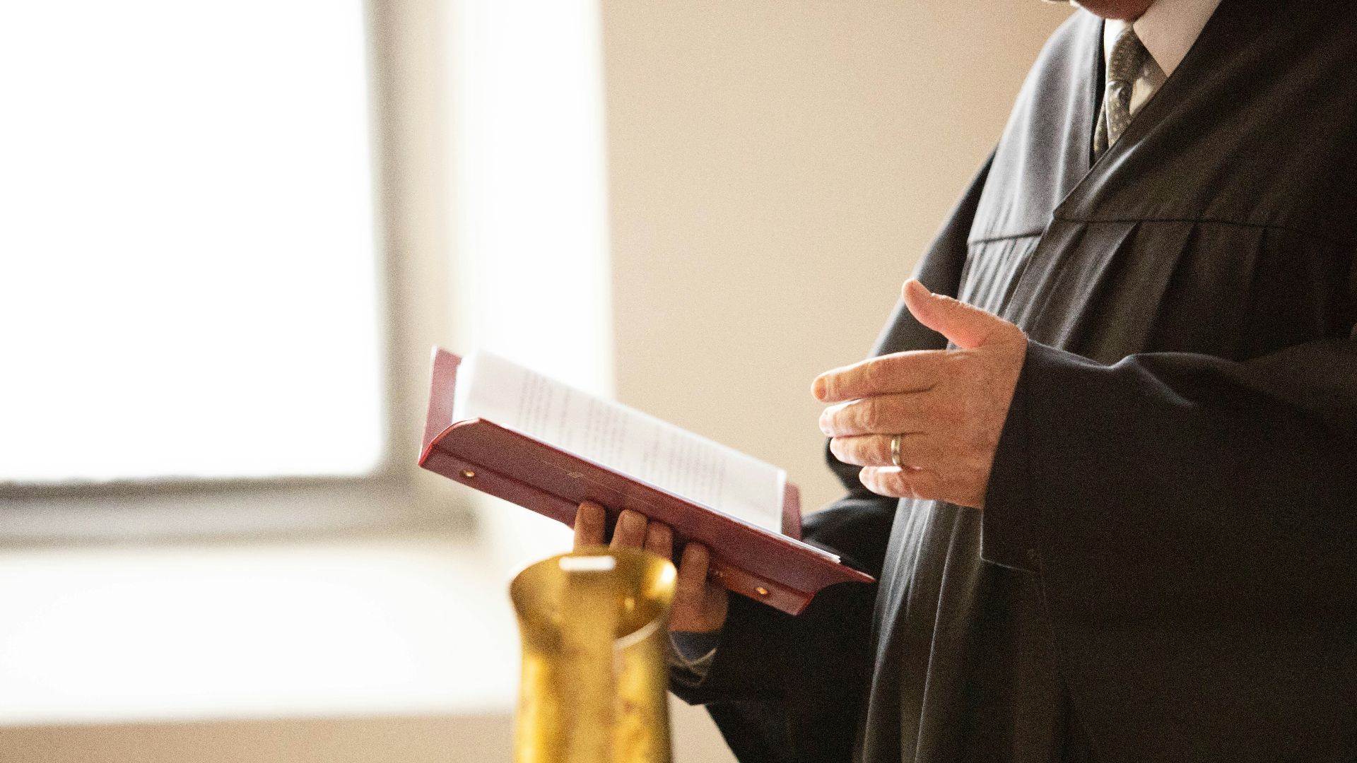 a man in a black robe holding a book