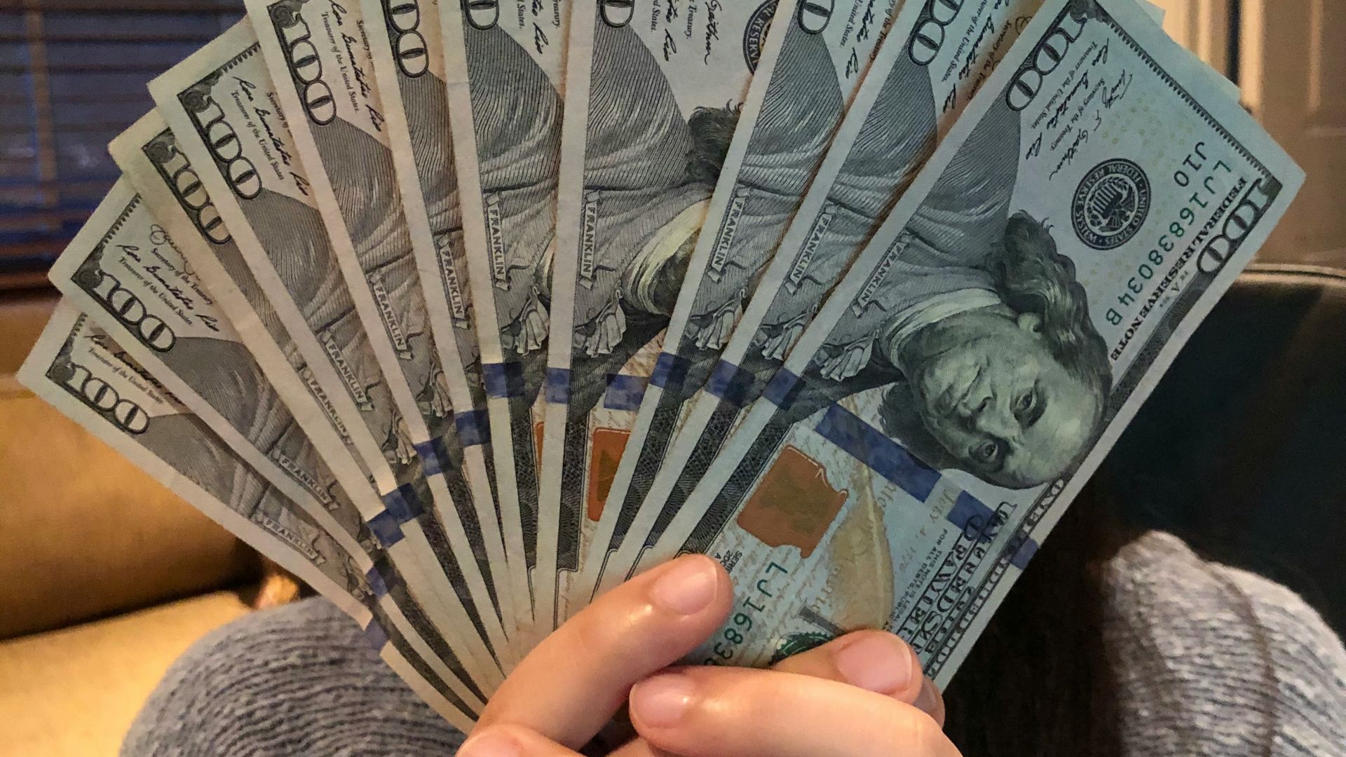 person holding fan of us dollar bill