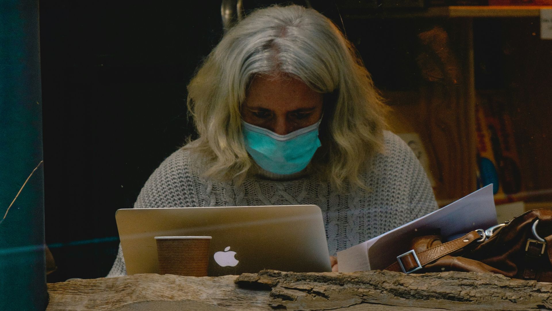 woman in blue and white plaid shirt wearing black framed eyeglasses holding white ceramic mug